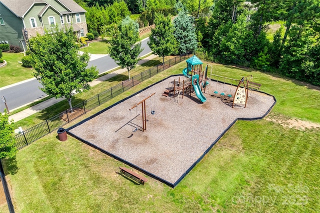 community play area featuring fence and a yard