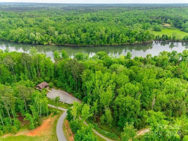 drone / aerial view featuring a view of trees and a water view