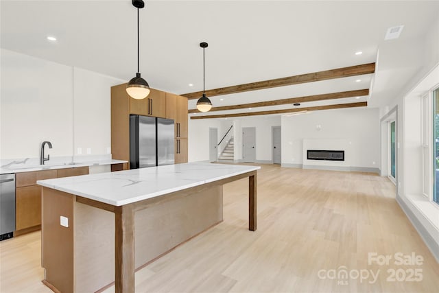 124 Clipper Ln, Mooresville, NC 28117 - kitchen featuring appliances with stainless steel finishes, light wood finished floors, a center island, modern cabinets, and light stone counters