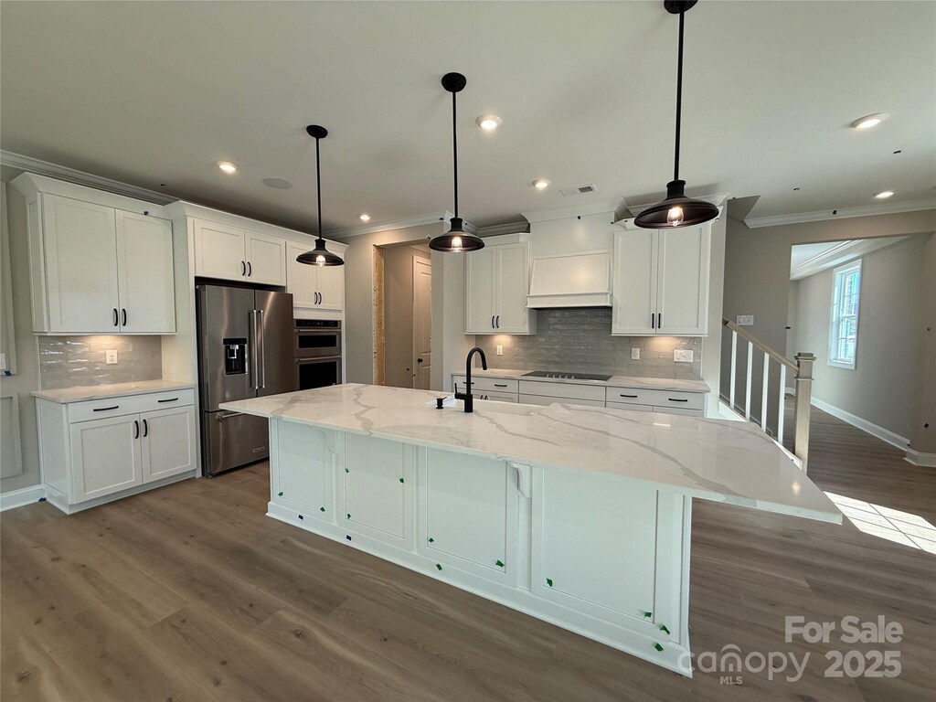 kitchen featuring white cabinets, appliances with stainless steel finishes, and ornamental molding