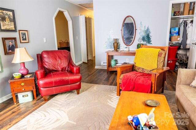 living area with baseboards, a baseboard heating unit, and wood finished floors