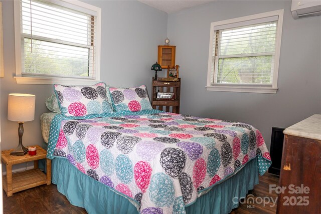 bedroom featuring a wall mounted AC and wood finished floors
