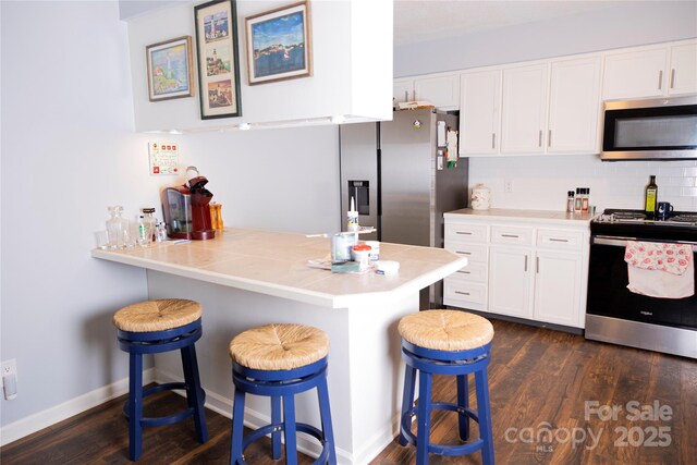 57 Gribble Rd, Franklin, NC 28734 - kitchen with stainless steel appliances, a breakfast bar area, and white cabinetry