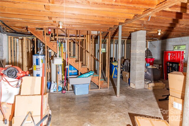 57 Gribble Rd, Franklin, NC 28734 - unfinished below grade area with electric water heater, concrete block wall, and stairs