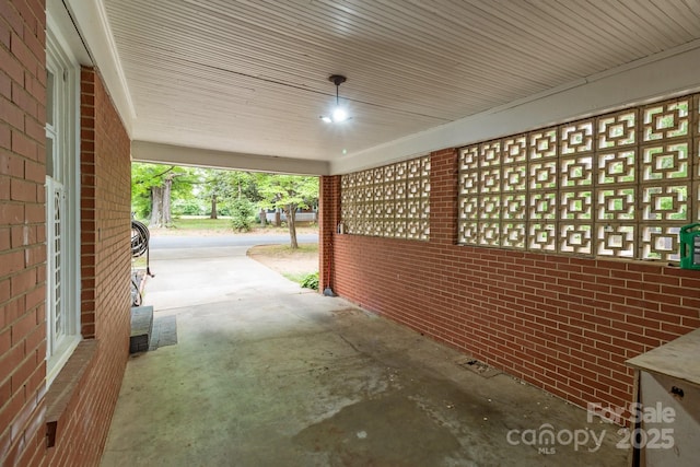 view of property exterior with an attached carport and brick siding