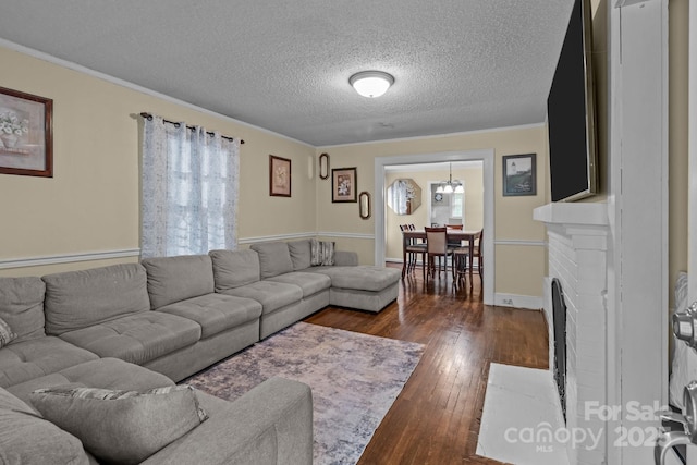 living area featuring a healthy amount of sunlight, a brick fireplace, dark wood-style floors, and a textured ceiling