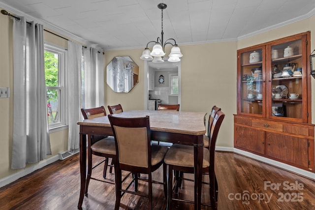 dining room with visible vents, ornamental molding, a chandelier, and dark wood-style floors