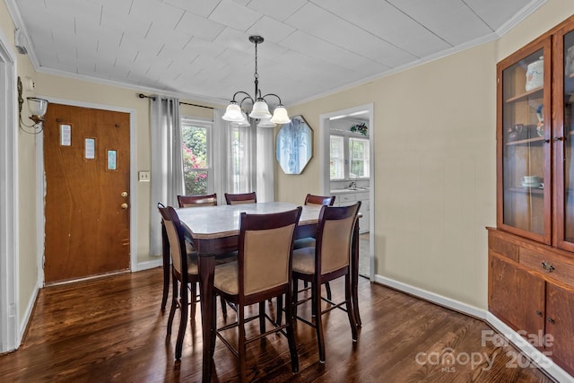 dining room with ornamental molding, dark wood-style flooring, a notable chandelier, and a wealth of natural light