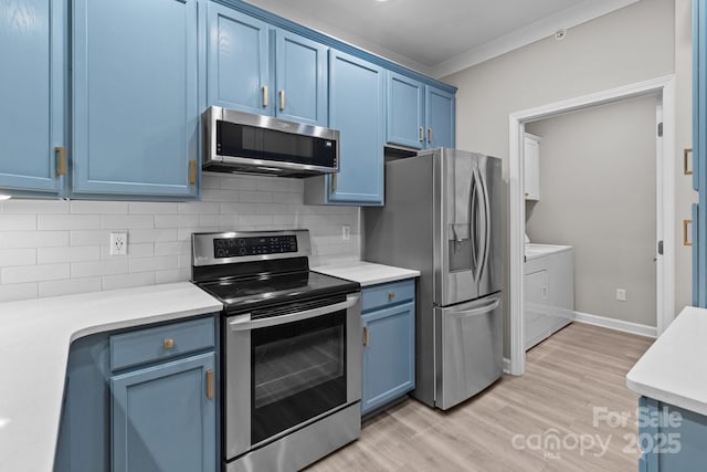 kitchen featuring backsplash, blue cabinets, appliances with stainless steel finishes, light countertops, and separate washer and dryer