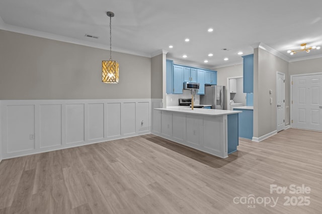 kitchen with light countertops, stainless steel appliances, visible vents, ornamental molding, and blue cabinets