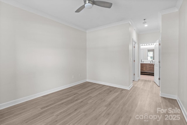 empty room featuring crown molding, baseboards, a ceiling fan, and light wood-style flooring