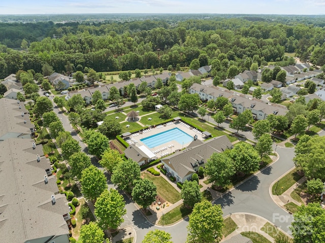 drone / aerial view featuring a residential view and a wooded view