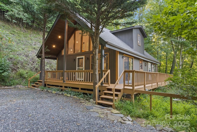 exterior space featuring covered porch and a shingled roof