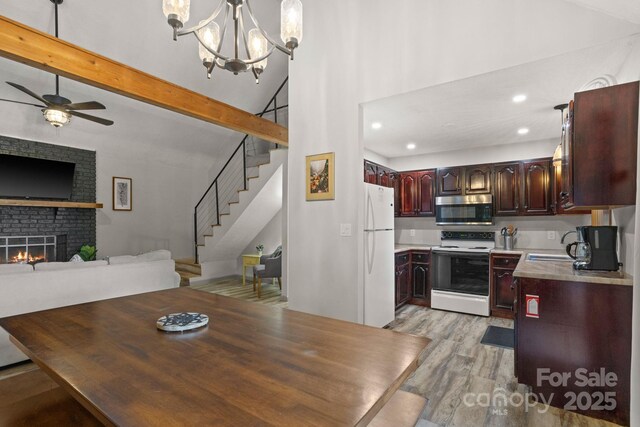kitchen with white appliances, light countertops, recessed lighting, open floor plan, and light wood-type flooring