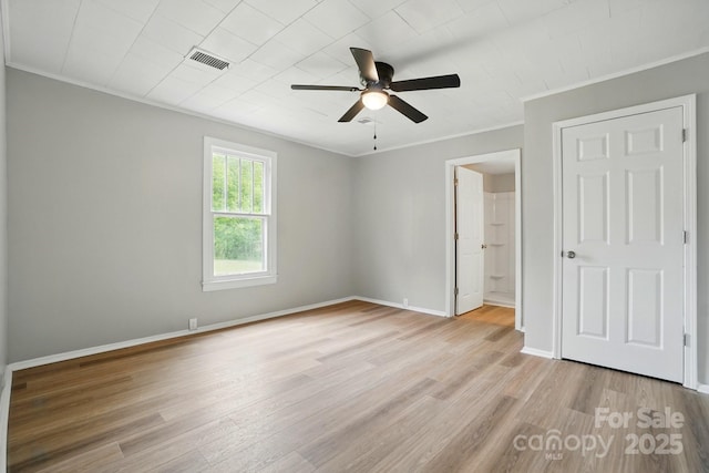 unfurnished bedroom with visible vents, ornamental molding, light wood finished floors, and baseboards