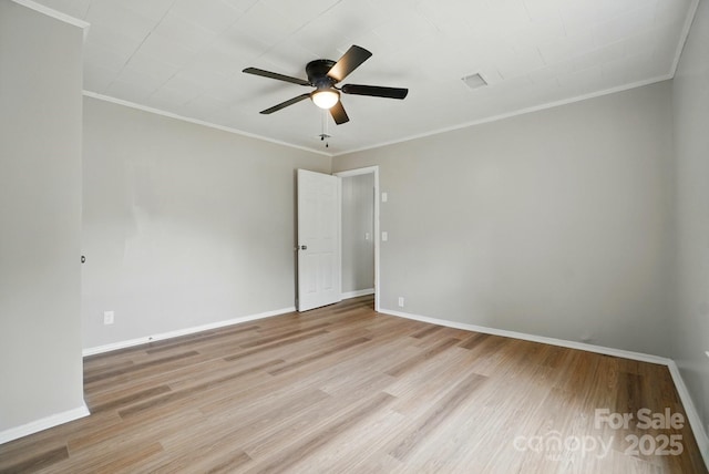 spare room with light wood-type flooring, a ceiling fan, baseboards, and crown molding