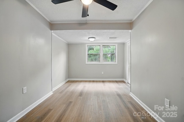 empty room featuring crown molding, a textured ceiling, and wood finished floors