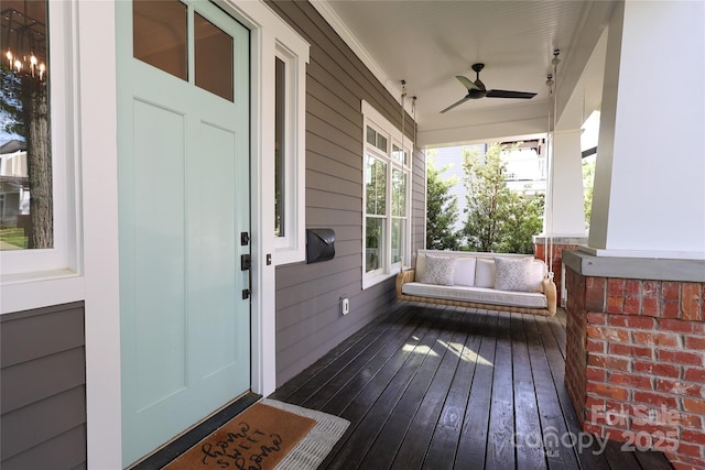 wooden terrace with ceiling fan and covered porch