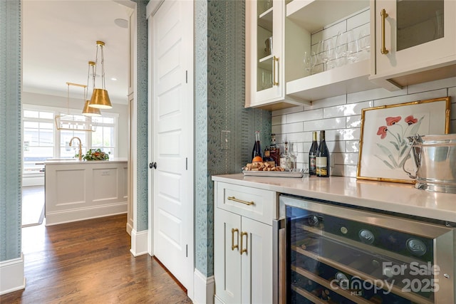 bar featuring a dry bar, beverage cooler, dark wood-style flooring, hanging light fixtures, and tasteful backsplash