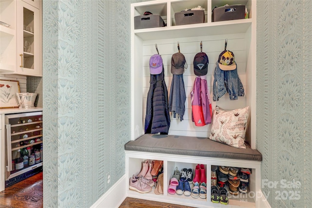 mudroom featuring wine cooler, wallpapered walls, and wood finished floors