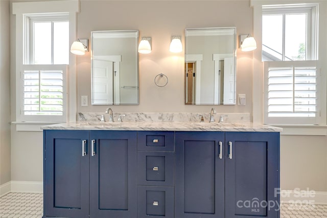 bathroom featuring plenty of natural light, baseboards, and a sink
