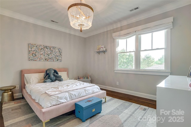 bedroom with baseboards, a notable chandelier, visible vents, and wood finished floors