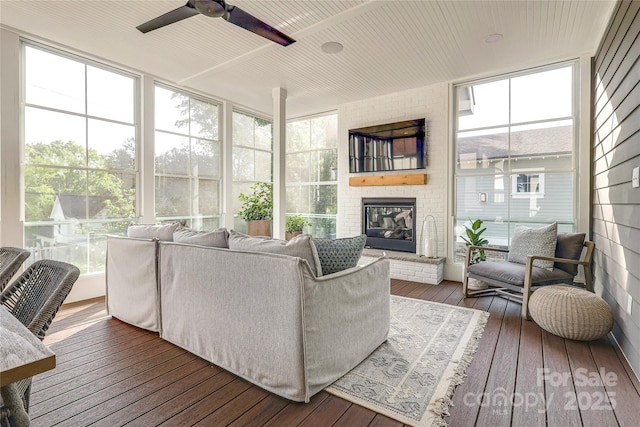 sunroom / solarium featuring an outdoor living space with a fireplace and ceiling fan
