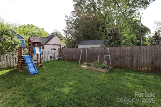 view of yard featuring a fenced backyard, a garden, and a playground