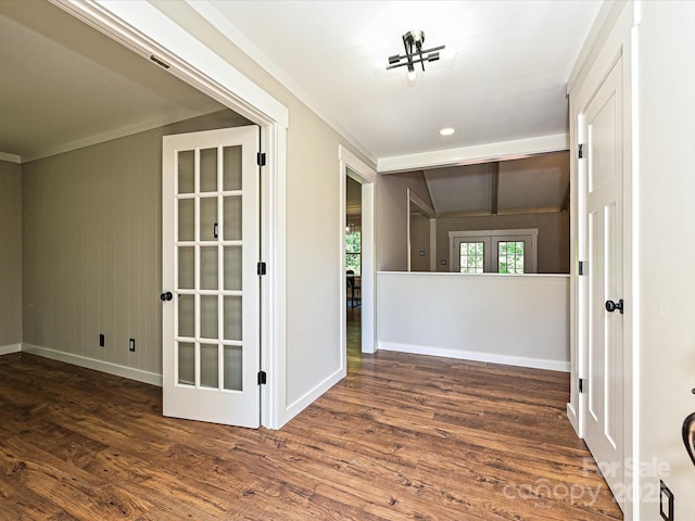 empty room with crown molding, baseboards, and wood finished floors