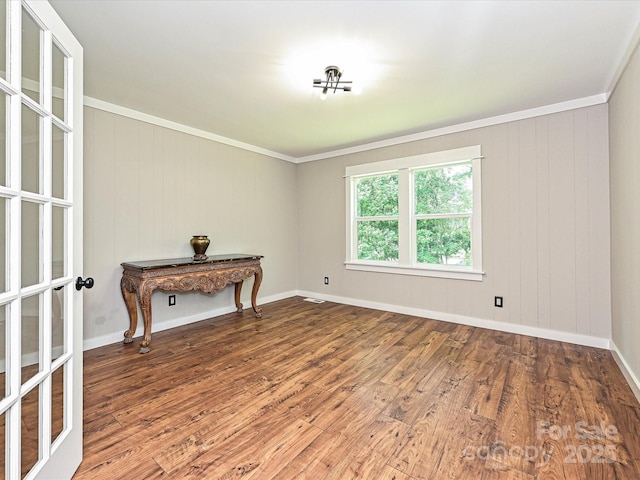 unfurnished room with baseboards, visible vents, ornamental molding, and wood finished floors
