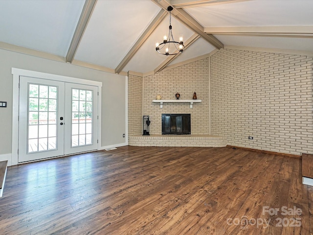 unfurnished living room featuring lofted ceiling with beams, brick wall, a chandelier, dark wood finished floors, and french doors
