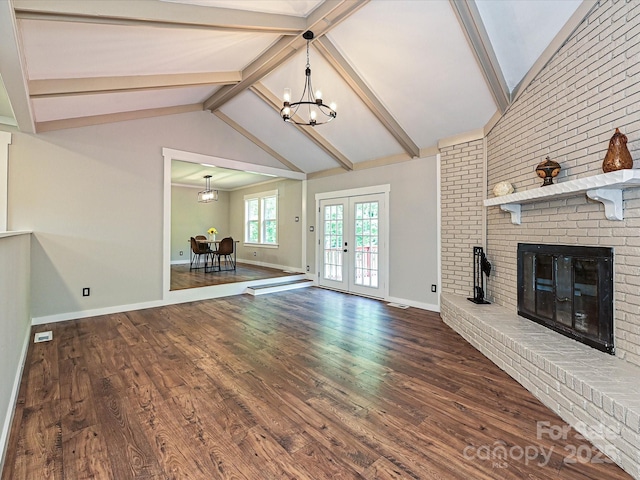 unfurnished living room featuring french doors, a fireplace, wood finished floors, baseboards, and a notable chandelier