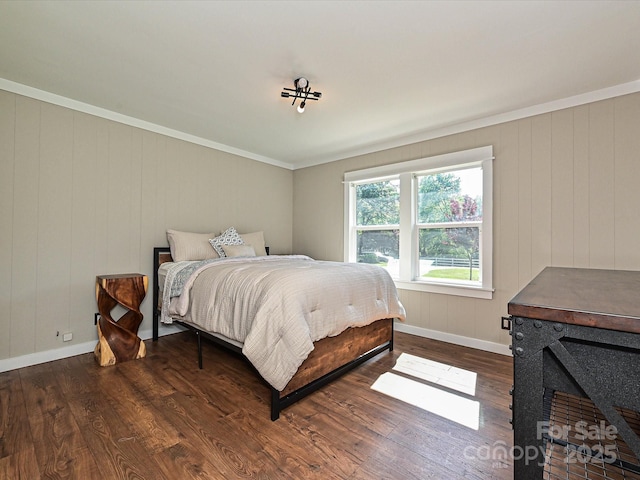 bedroom featuring crown molding, baseboards, and wood finished floors