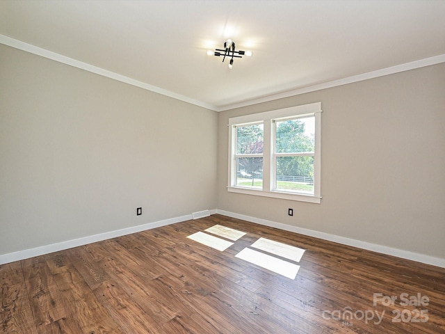 spare room with baseboards, crown molding, dark wood-style floors, and visible vents