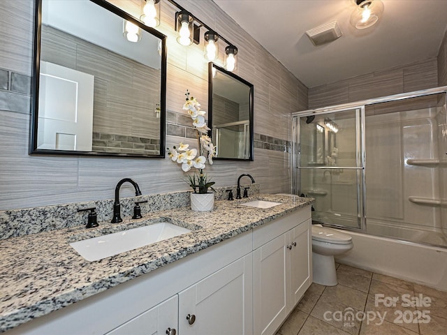 full bath featuring a sink, tile patterned floors, toilet, and double vanity