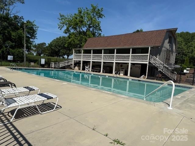community pool featuring fence, a patio area, and stairway