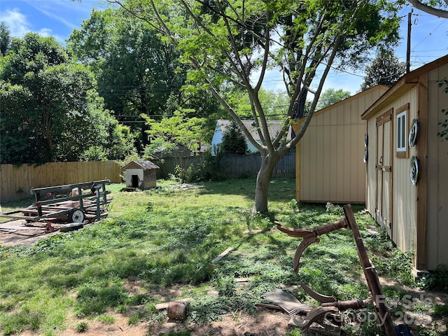 view of yard with a storage shed, an outbuilding, and a fenced backyard