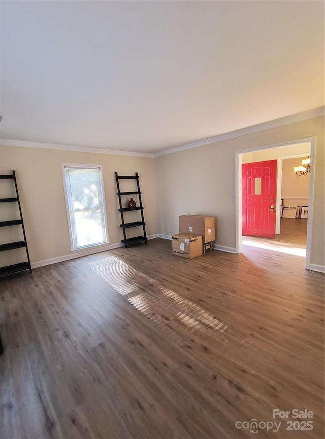 5601 Carmel Station Ave, Charlotte, NC 28226 - unfurnished living room featuring ornamental molding, a chandelier, wood finished floors, and baseboards