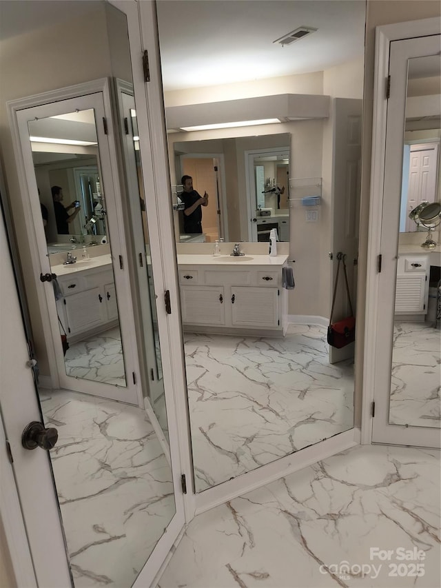5601 Carmel Station Ave, Charlotte, NC 28226 - bathroom with marble finish floors, two vanities, and baseboards