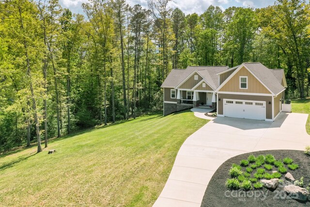 craftsman house featuring board and batten siding, driveway, and a front yard