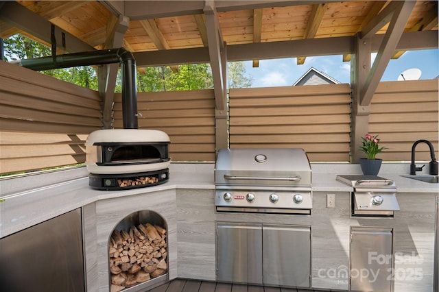 view of patio featuring grilling area, exterior kitchen, and a sink