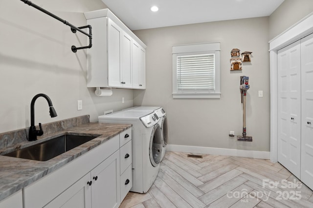 laundry room with washing machine and dryer, baseboards, recessed lighting, a sink, and cabinet space