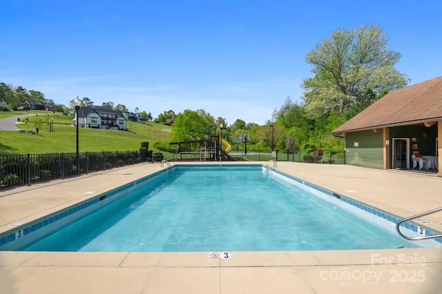 community pool featuring fence, a yard, and playground community