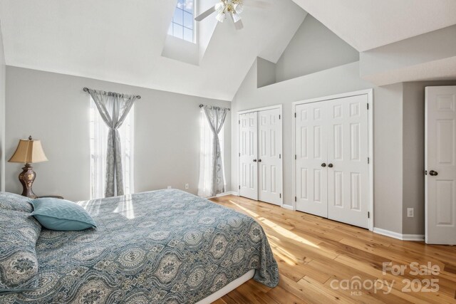 3223 Rheinwood Ct, Matthews, NC 28105 - bedroom featuring high vaulted ceiling, two closets, wood finished floors, baseboards, and ceiling fan
