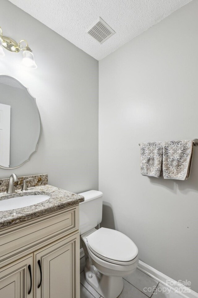 3223 Rheinwood Ct, Matthews, NC 28105 - bathroom with vanity, toilet, a textured ceiling, tile patterned flooring, and baseboards