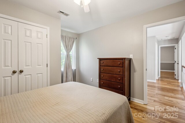 3223 Rheinwood Ct, Matthews, NC 28105 - bedroom featuring light wood-style flooring, a closet, baseboards, and a ceiling fan