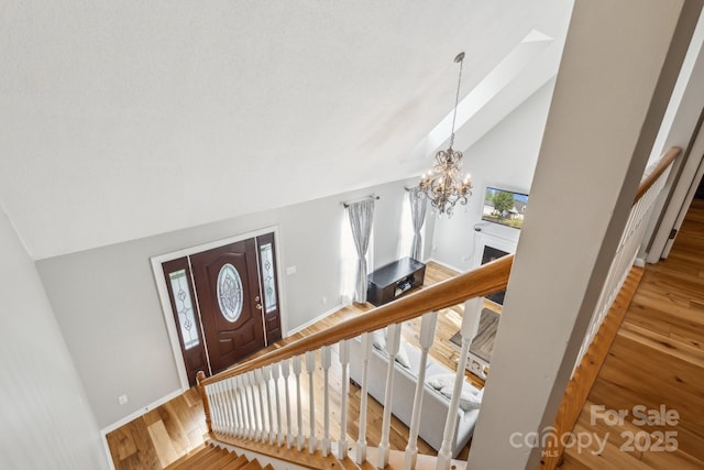 3223 Rheinwood Ct, Matthews, NC 28105 - entrance foyer featuring wood finished floors, a chandelier, baseboards, stairs, and high vaulted ceiling