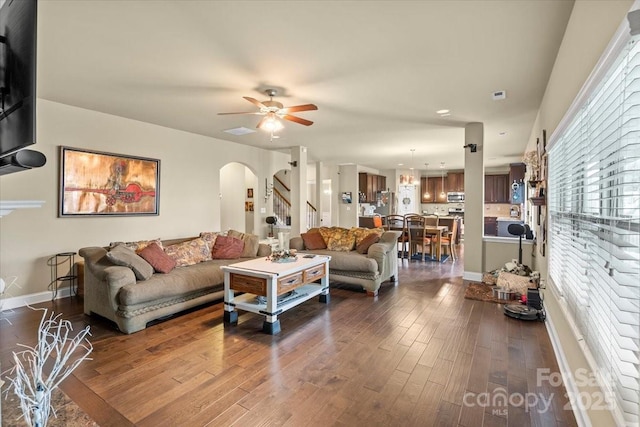 1011 Potomac Rd, Indian Trail, NC 28079 - living room with arched walkways, ceiling fan, dark wood-style flooring, stairs, and baseboards