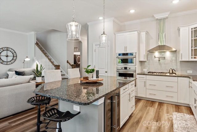 1260 Thomas Knapp Pkwy, Fort Mill, SC 29715 - kitchen with crown molding, wine cooler, a breakfast bar area, wall chimney exhaust hood, and stainless steel appliances
