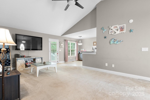living room with a ceiling fan, baseboards, light colored carpet, and high vaulted ceiling